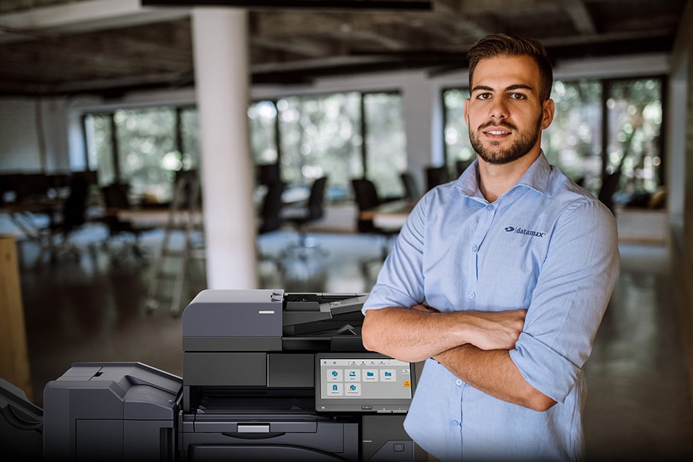 A Datamax employee standing next to a printer